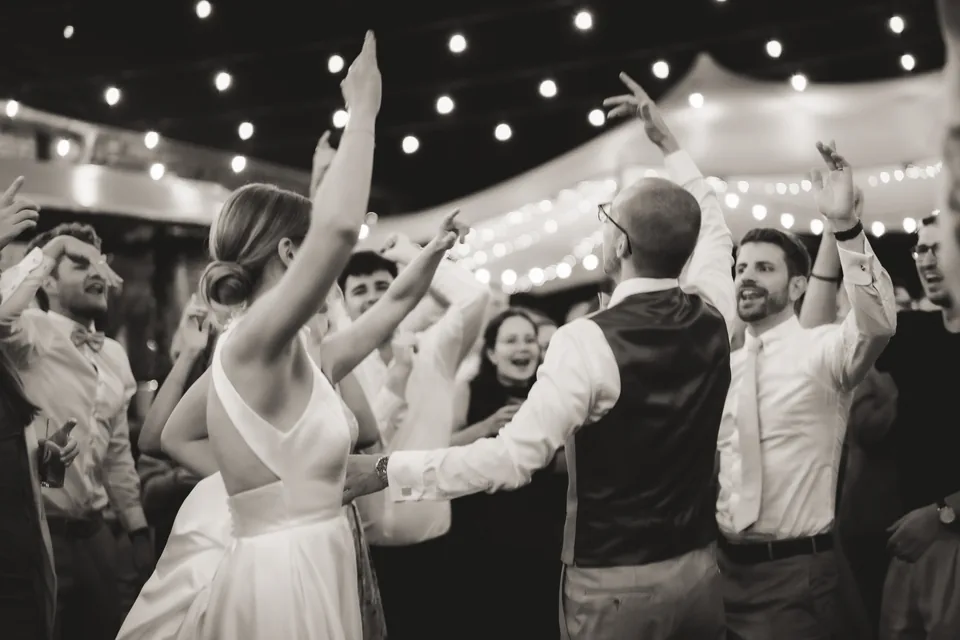 Brautpaar und Gäste feiern gemeinsam auf einer Hochzeit.