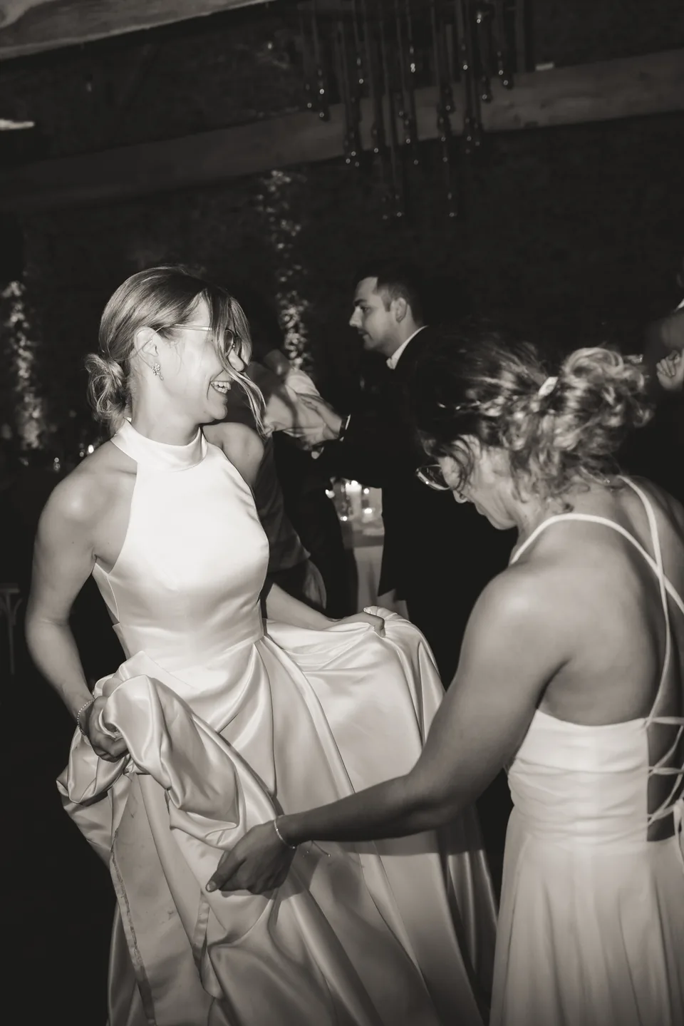 Braut und Gäste feiern lachend auf einer Hochzeit.